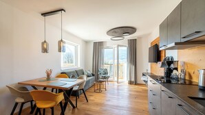 A modern kitchen with a built-in oven, a coffee machine, and a wooden countertop. - Apartment Multicolor Amethyst at Wolfgangsee Alpenblick (St. Wolfgang)