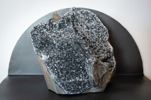 Una escultura de roca amb una textura rugosa i aspecte metàl·lic fosc.