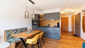 Eine moderne Küche mit grauen Schränken, einem Holztisch und einer Bank.