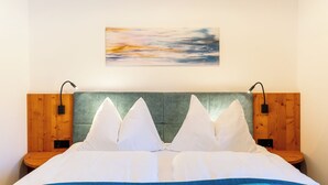 Ein Bett mit einem grünen Kopfteil, weißen Kissen und einer blauen Decke.