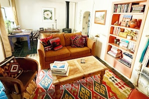 Ein gemütliches Wohnzimmer mit Sofa, Couchtisch, Bücherregal und Kamin.
