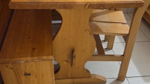 Ett matbord i trä med en bänk, omgivet av stolar.