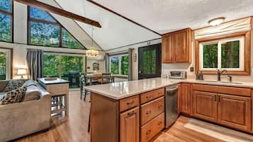 A spacious kitchen with wooden cabinets, a large island, and a dining area with a sofa and table.
