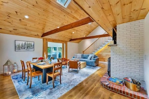 A wooden ceiling, a dining area with a table and chairs, a sofa, a fireplace, and a staircase. - Summitgrove Cabin w/ Hot tub, Game Room &OutdoorTV (Long Pond)