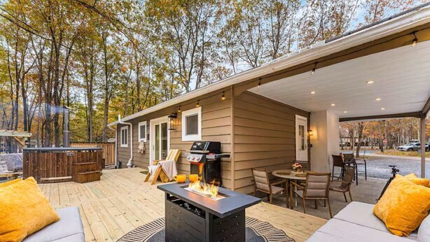 Un patio techado al aire libre con una parrilla, zona de estar y una chimenea.