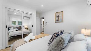 Un dormitorio moderno con una cama grande, una cama más pequeña y un vestidor.