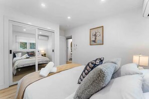 A modern bedroom with a large bed, a smaller bed, and a walk-in closet. - Woodland Cabin w/ Hot Tub, Game Room & Outdoor TV (Albrightsville)