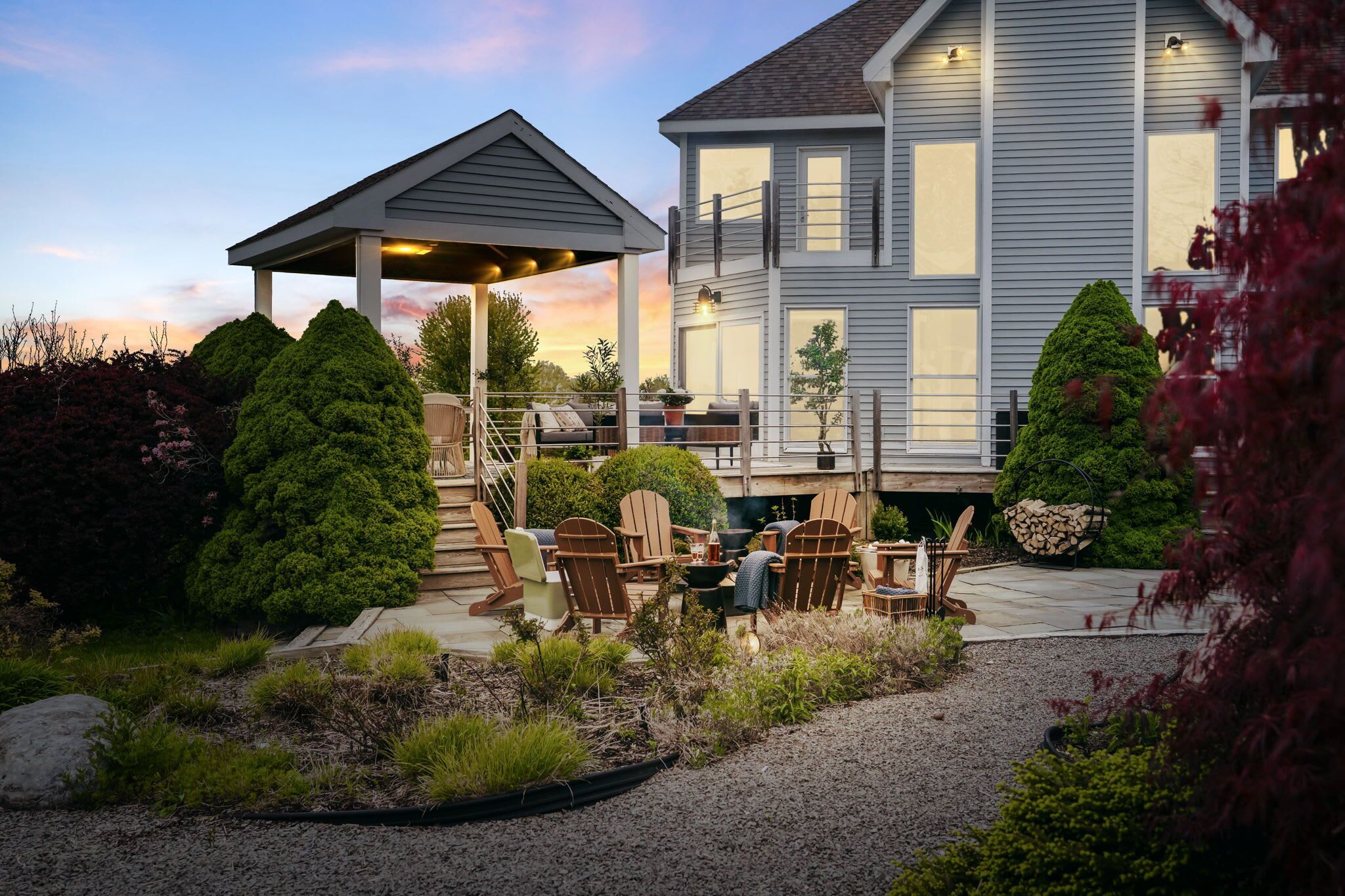 Une maison dotée d’un patio couvert, d’un espace salon extérieur et d’un jardin bien entretenu.