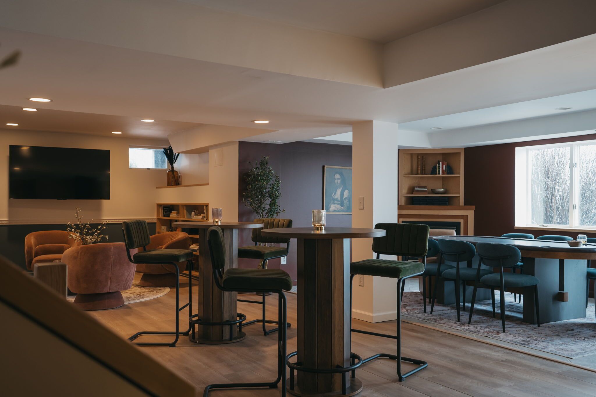 A modern living room with a central coffee table, seating area, and a television mounted on the wall.
