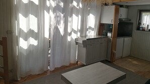 Een keuken met witte kastjes, een houten aanrecht en een hanglamp.