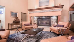 A living room with a fireplace, leather sofas, a coffee table, and a rug. - Wisconsin Dells Family Stay with Water Park Access & Spacious 2BR Suite (Wisconsin Dells)
