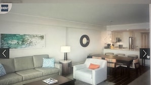 A modern living room with a sofa, armchair, coffee table, and a dining area with a table and chairs. - Ocean Front View Hilton Head Island 2 bedroom Condo sleeps 8 w/ Golf access (Hilton Head Island)