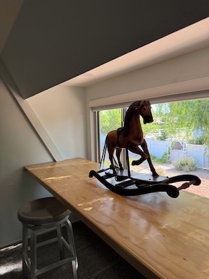 A wooden table with a rocking horse in a room with a window. - Welcome to the Red Barn House: 3BR 2BA country living in Santa Ynez Valley (Santa Ynez)