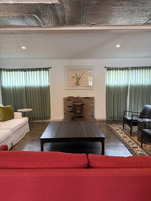 Ein Wohnzimmer mit Kamin, Sofa, Tisch und Sessel.