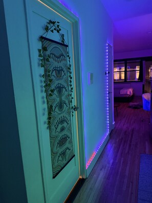 A hallway with a decorative door, a wall-mounted air vent, and a window with blinds. - Artist's Apartment in Manhattan (New York)