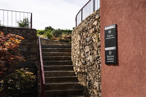 Una escalera de piedra que lleva a una zona de piscina, con un cartel que señala un lugar para desayunar.