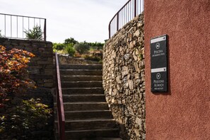 A stone staircase leading to a swimming pool area, with a sign indicating a breakfast spot. - Casa da Francelina - Douro Valley (Peso da Régua)