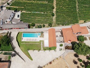 Vista aèria d'una propietat amb piscina, pista de tennis i un vinícola.