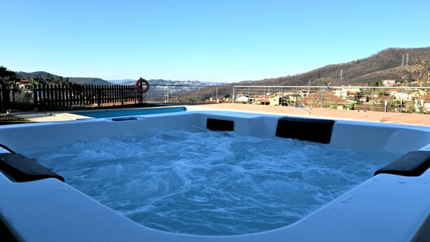 Ein Whirlpool mit Blick auf einen Berg und einen Pool.