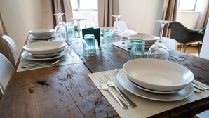 Una mesa de comedor de madera dispuesta con platos, vasos y cubiertos.