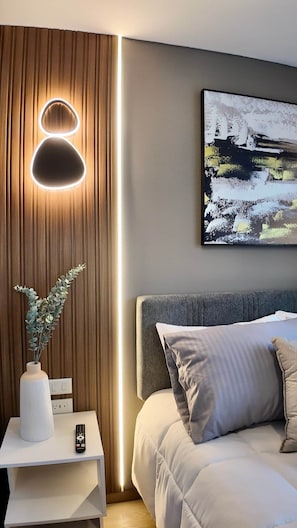 A modern bedroom with a bed, bedside table, and a wall-mounted light fixture. - Modern Studio by La Carolina Park & Metro +Free WIFI (Quito)
