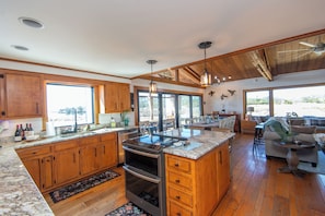 A spacious kitchen with wooden cabinets, a large island, and a dining area with a view.
