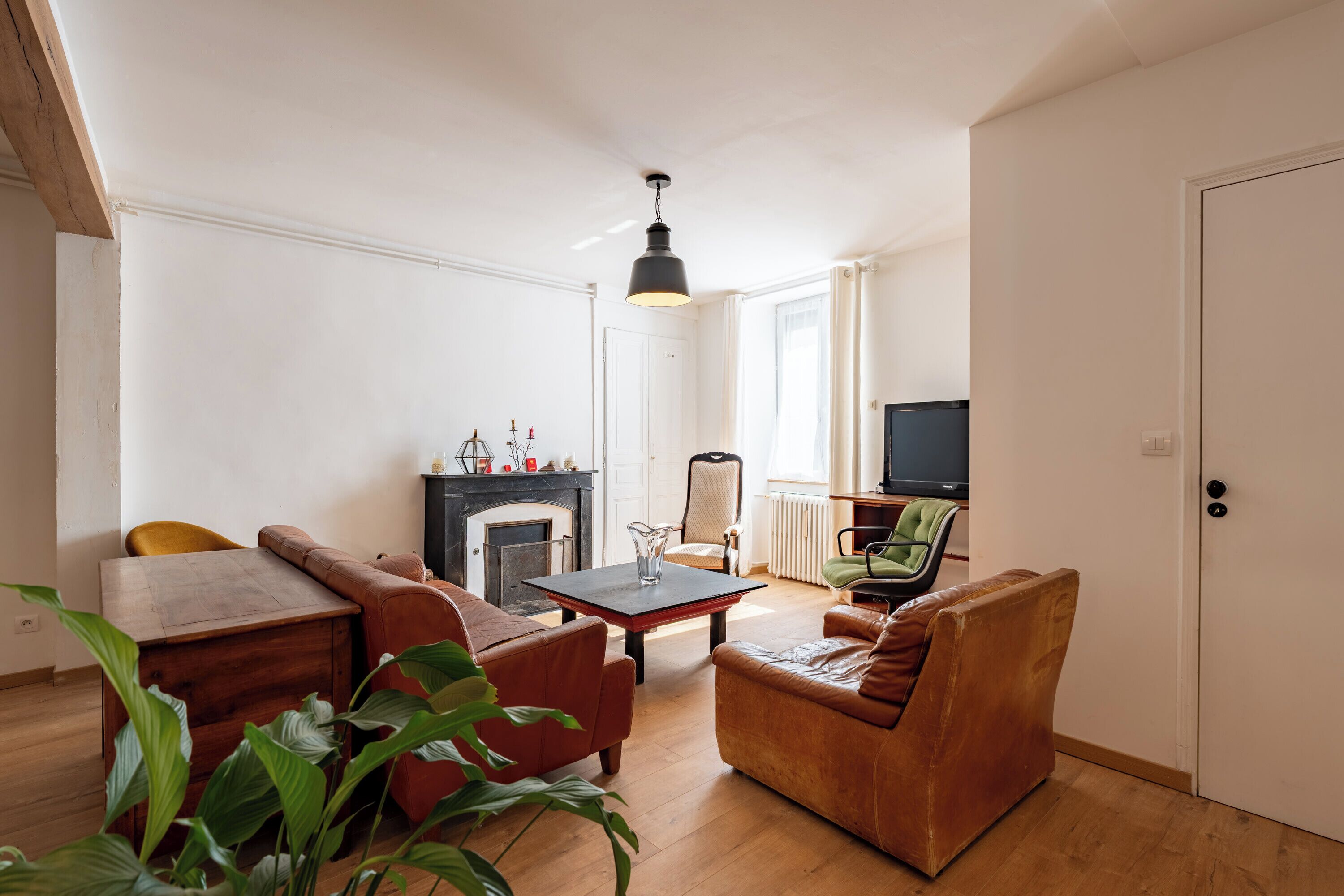 A living room with a fireplace, a television, and a sofa.