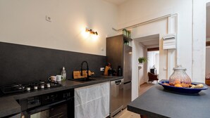 A modern kitchen with a stove, sink, dishwasher, and refrigerator.