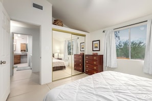 Un dormitorio con cama, cómoda, espejo y ventana.