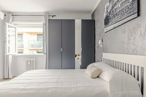 A bedroom with a bed, a radiator, a window, and a grey wardrobe. - [luggage storage] - La Bellavita Trastevere (Roma)