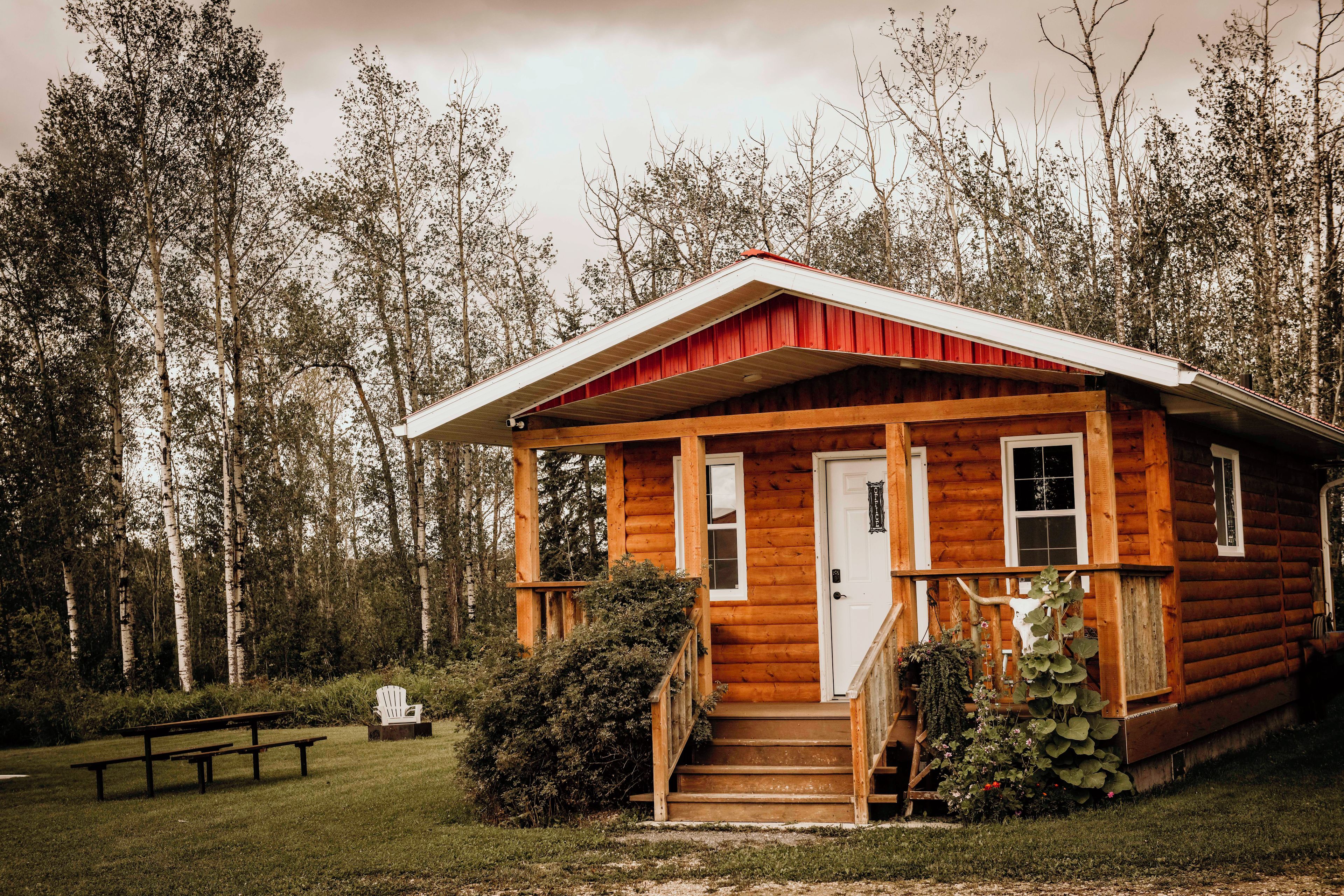 Une cabane en bois avec une véranda, une porte et une fenêtre.