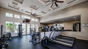 Une salle de sport équipée de tapis de course, de vélos elliptiques et de matériel de musculation.