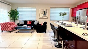 Un salon moderne comprenant un canapé, une table basse et un coin repas avec des chaises et une table.