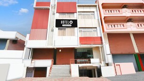 A hotel with a sign reading 'HOTELO & Company Serviced,' a staircase, and a red and white facade. - Deluxe With Twin Bed Lotus Park Hotel (Visakhapatnam)