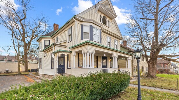 A two-story house with a front porch, a garage, and a driveway.