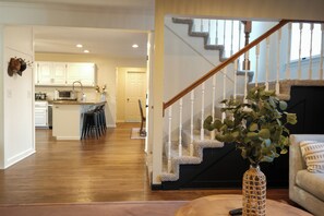 Un intérieur de maison comprenant une cuisine, un coin repas et un salon.