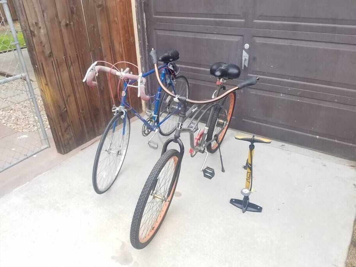 A bicycle and a pump leaning against a garage door.
