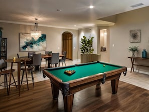 A pool table in a room with a dining area, a chandelier, and a painting on the wall. - Pool Table Fire Pit Spacious Disney Retreat (Placentia)