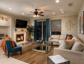 A living room with a fireplace, a ceiling fan, and a large window with curtains. - Pool Table Fire Pit Spacious Disney Retreat (Placentia)