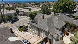 A residential area with a house featuring a sloped roof, a garage, and a driveway. - Ocean View, Hot Tub, Sauna, Beach Bikes + More (Ventura)