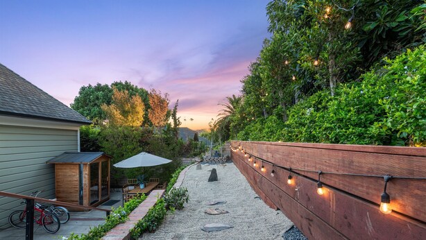 A pathway with stepping stones, a wooden fence, string lights, and a shed. - Ocean View, Hot Tub, Sauna, Beach Bikes + More (Ventura)