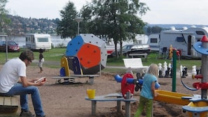 A playground with a seesaw, a climbing structure, and a sandpit. - Siljansbadets Camping (Rattvik)