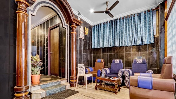 A spacious lobby with a marble floor, a reception desk, and a seating area with leather chairs. - Hotel O Hanuman Pet Railway Station (Vijayawada)