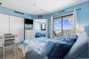 A bedroom with a bed, a desk, a chair, and a view of the sea. - NEWLY RENOVATED 1 Bedroom Ocean View (Myrtle Beach)