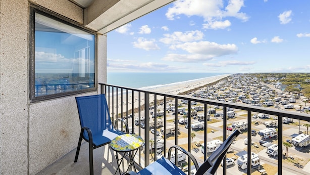 Un balcone con vista sulla spiaggia e un parcheggio per camper.