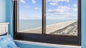 Una stanza con una grande finestra vista spiaggia e molo.