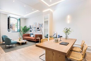 A modern living room with a wooden dining table, comfortable seating, and a large window. - Victoria XVII - Studio Apartment, Sleeps 2 (Malaga)