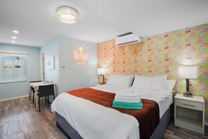 Hotellihuone, jossa on sänky, yöpöydät, työpöytä ja ikkuna.