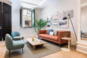 A modern living room with a sofa, chairs, a coffee table, and artwork on the walls. - Victoria XVI - Studio Apartment, Sleeps 2 (Malaga)