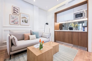 A modern living room with a sofa, coffee table, and artwork on the wall. - Victoria XVIII - Studio Apartment, Sleeps 2 (Malaga)